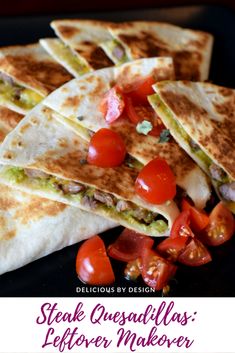 a black plate topped with quesadillas and tomatoes