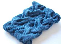 a blue knitted object on a white surface