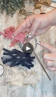 two hands holding scissors and sewing fabric on a table