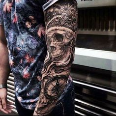 a man with a clock and skull tattoo on his arm