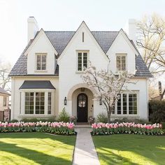 a white house with flowers in the front yard