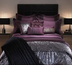 a bed with purple and silver sequins on the comforter, pillows and blankets