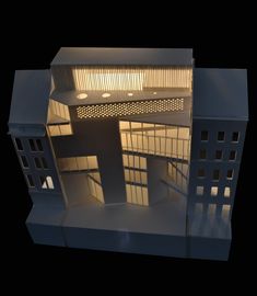 an architectural model of a building with lights on