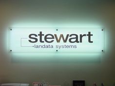 there is a sign that says stewart land data systems on the wall in front of it