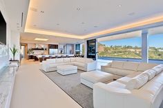 a living room with white furniture and large windows