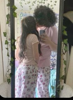 two girls are standing in front of a mirror