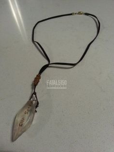 a necklace with a leaf shaped pendant hanging from it's side