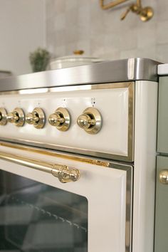 an oven with brass handles and knobs in a kitchen