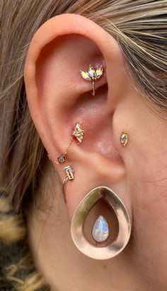 a close up of a person with ear piercings on their ears and behind the ear