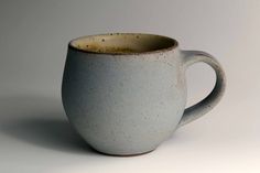 a white and gray coffee cup sitting on top of a table