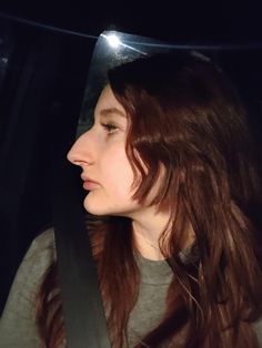 a woman sitting in the back seat of a car with her head turned to the side