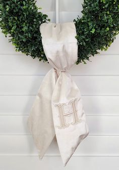 a white wreath with the letter h on it