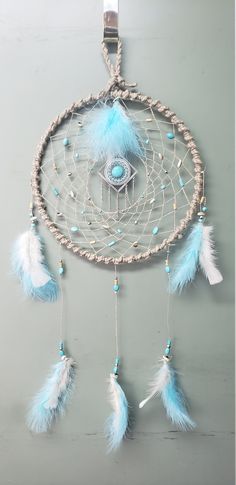 a blue and white dream catcher hanging on the wall