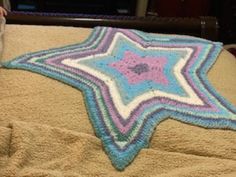 a crocheted star blanket on top of a bed