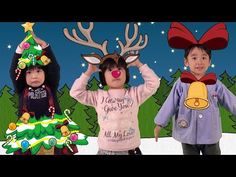 two children wearing reindeer antlers with christmas trees in the background