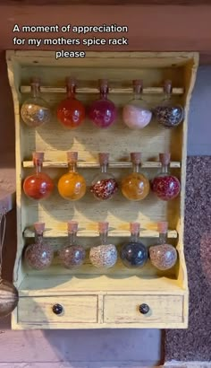 an old wooden cabinet with lots of different colored glass bottles on the top and bottom shelves