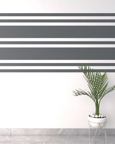 a potted plant sitting in front of a wall with vertical stripes on the wall