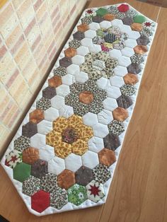 a close up of a table runner on a wooden floor near a brick wall and window