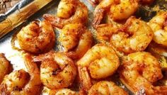 cooked shrimp on a baking sheet next to bread