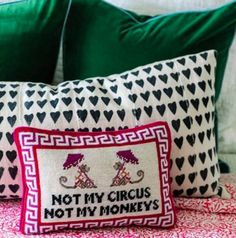 two decorative pillows sitting on top of a bed