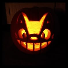 a pumpkin carved to look like an angry cat