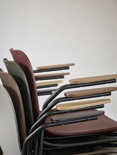 a stack of chairs sitting next to each other in front of a white wall and floor