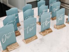 place cards are placed on wooden holders with white lettering that read table one, two, three