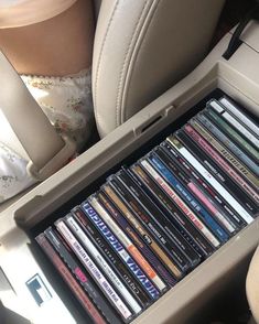 a bunch of cds in the back seat of a car, with someone's legs behind them