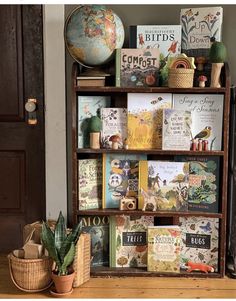 a bookshelf filled with lots of books on top of a wooden table next to a potted plant