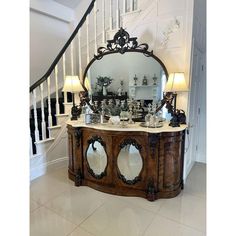 a large mirror sitting on top of a wooden cabinet next to a stair case in a house