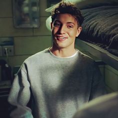 a young man standing in front of a bunk bed