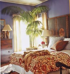 a bedroom with blue walls and carpeted flooring has a large bed in the center