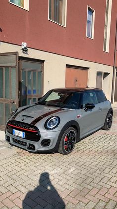 a grey and black car parked in front of a building