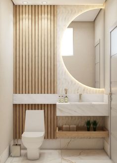 a white toilet sitting next to a bathroom sink under a round mirror in a bathroom