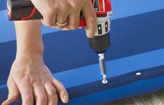 a person using a drill to fix a piece of furniture