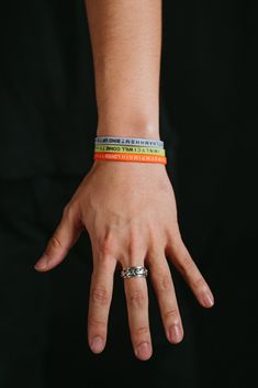 a person's hand with two bracelets on their wrists and one in the middle