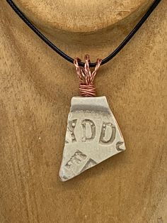 a necklace with a pendant that says add and has a small triangle on the front