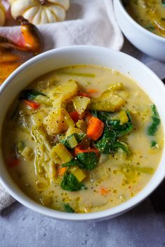 two white bowls filled with soup on top of a table