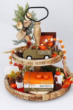 a three tiered display with pumpkins and decorations