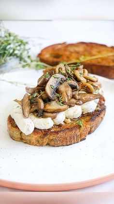 a plate topped with mushrooms and cheese on top of bread next to other food items