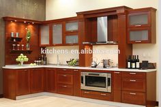 an image of a kitchen setting with wood cabinets and stainless steel stove top ovens