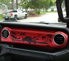 the interior of a truck with palm trees and trucks in the back ground behind it