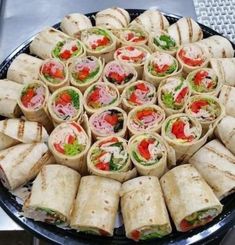 a platter filled with lots of different types of sandwiches