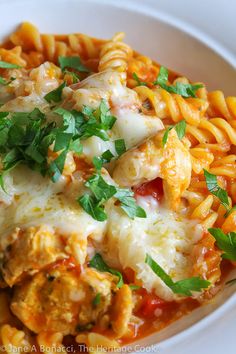 pasta with meat, cheese and parsley in a white bowl