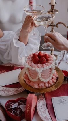 a woman holding a wine glass over a cake