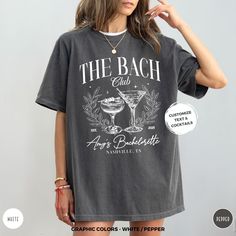 a woman wearing a t - shirt that says the beach club with an image of a cocktail glass on it