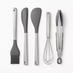 an assortment of kitchen utensils on a white surface