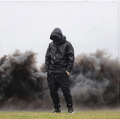 a man standing on top of a grass covered field next to a fire hydrant