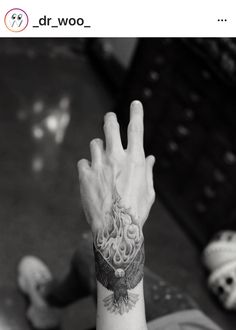 a person with a tattoo on their arm is holding his hand up in the air