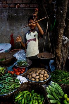 a man standing in front of baskets filled with vegetables